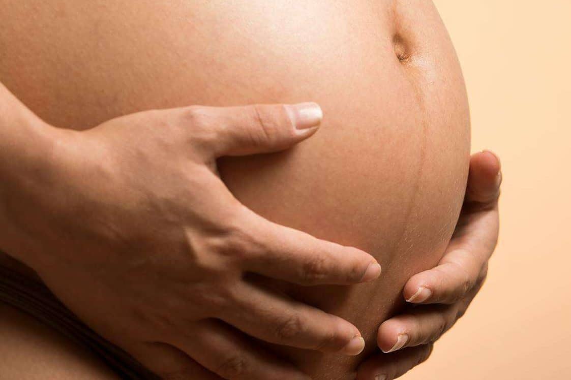Hands on a pregnant belly demonstrating birth doula support in Birmingham, Alabama.